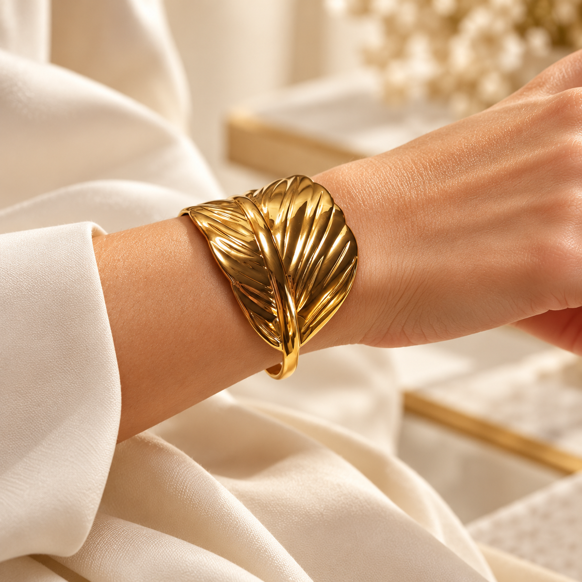 Bracelet Plume doré — porté au poignet.