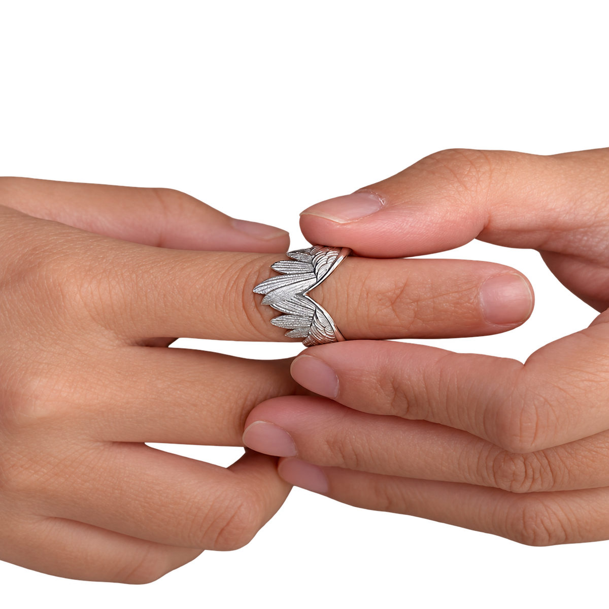 Bague Ailes d’ange argentée portée au doigt et présentée entre les mains.