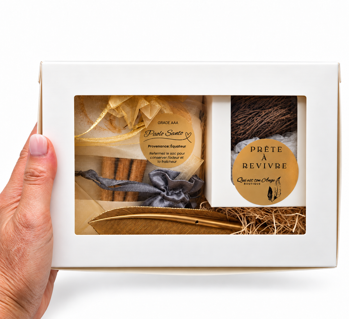 Coffret spirituel tenu dans une main, avec les produits visibles par la fenêtre.
