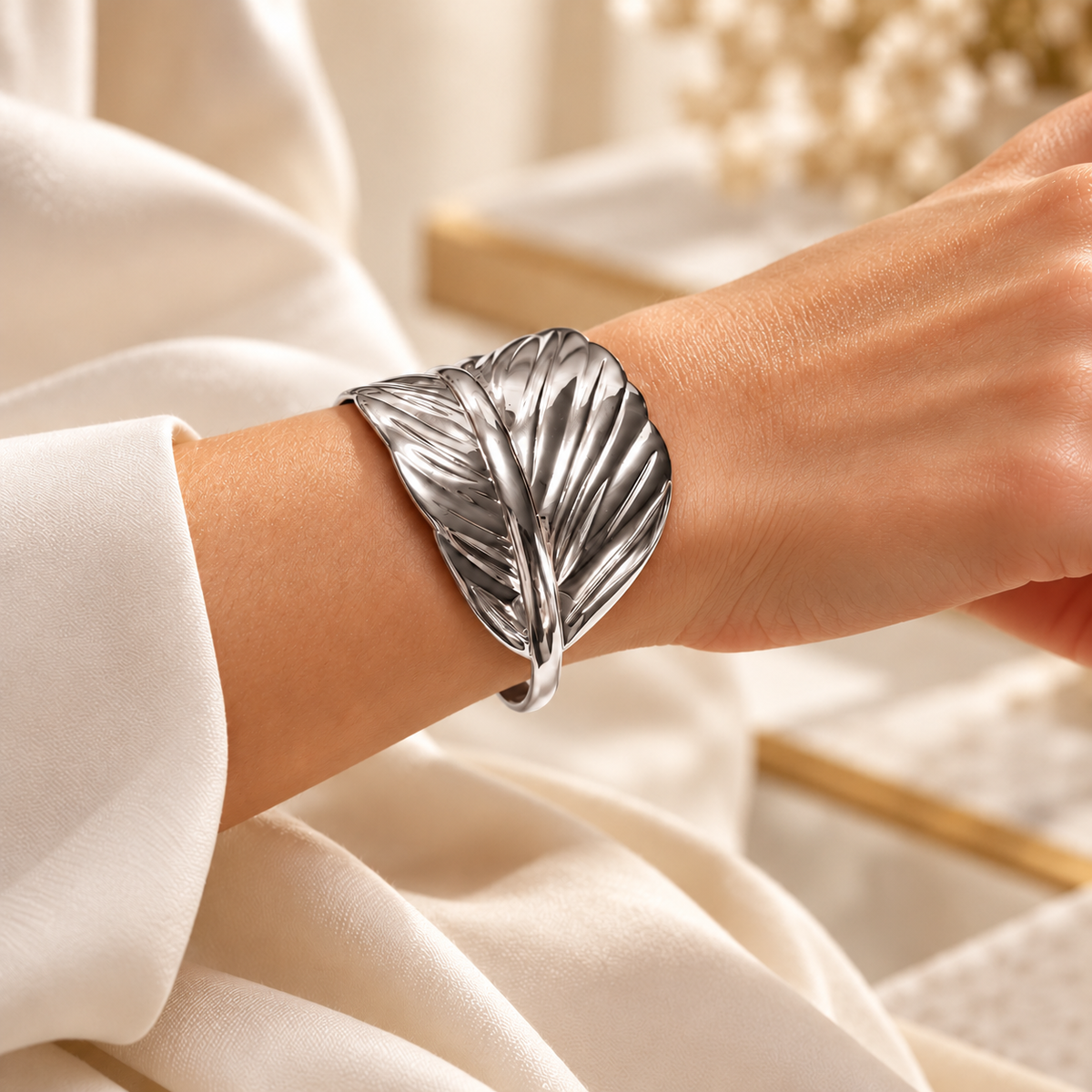 Bracelet Plume argenté — porté au poignet.