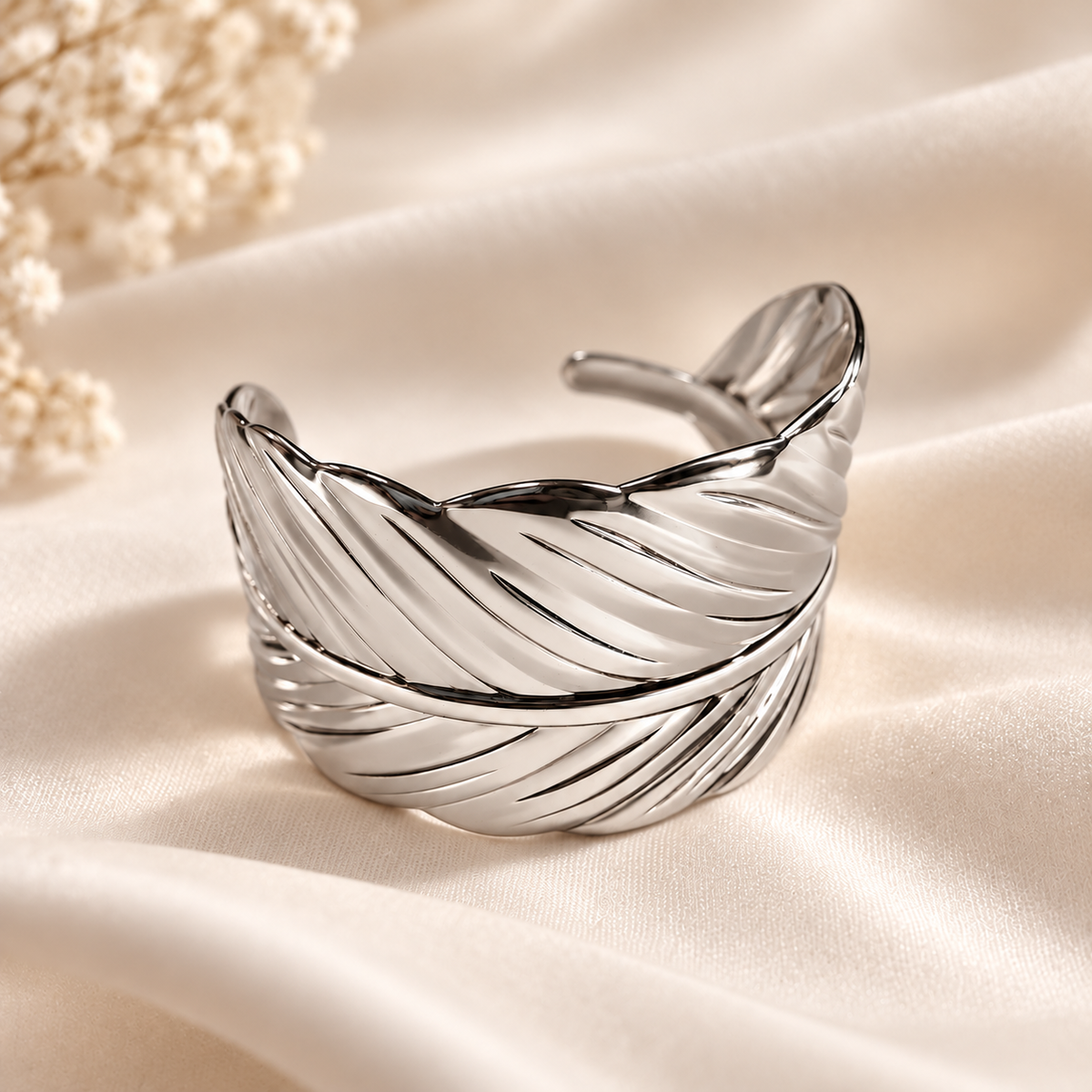 Bracelet Plume argenté — sur tissu satiné.